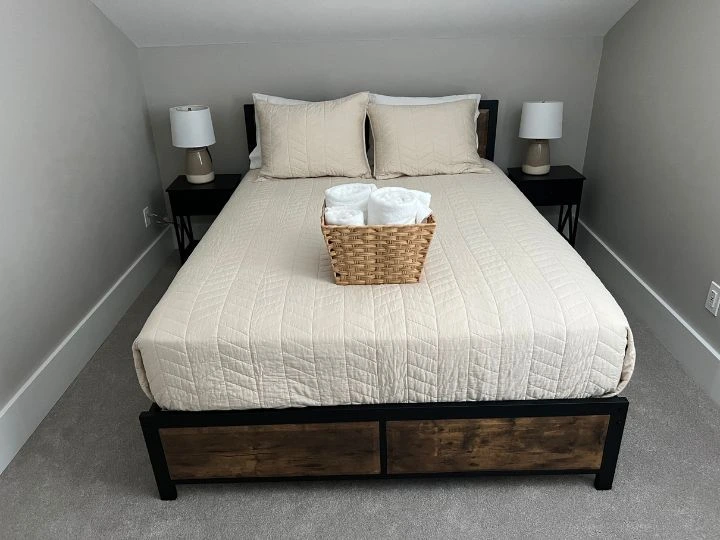 A freshly cleaned residential bedroom with a made bed, dusted furniture, and a tidy space