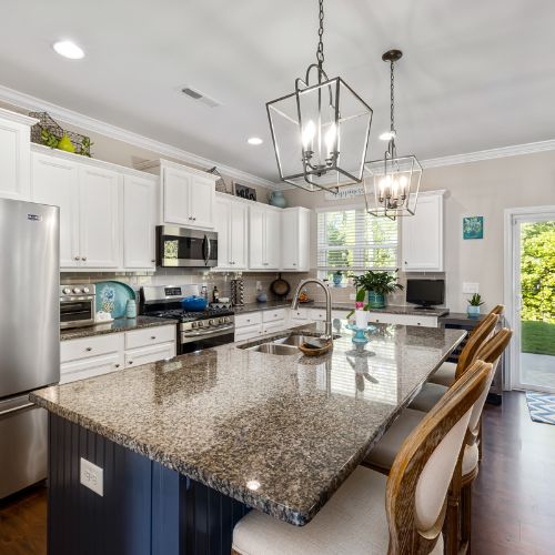 A freshly cleaned residential kitchen with gleaming countertops, spotless appliances, and a sparkling sink